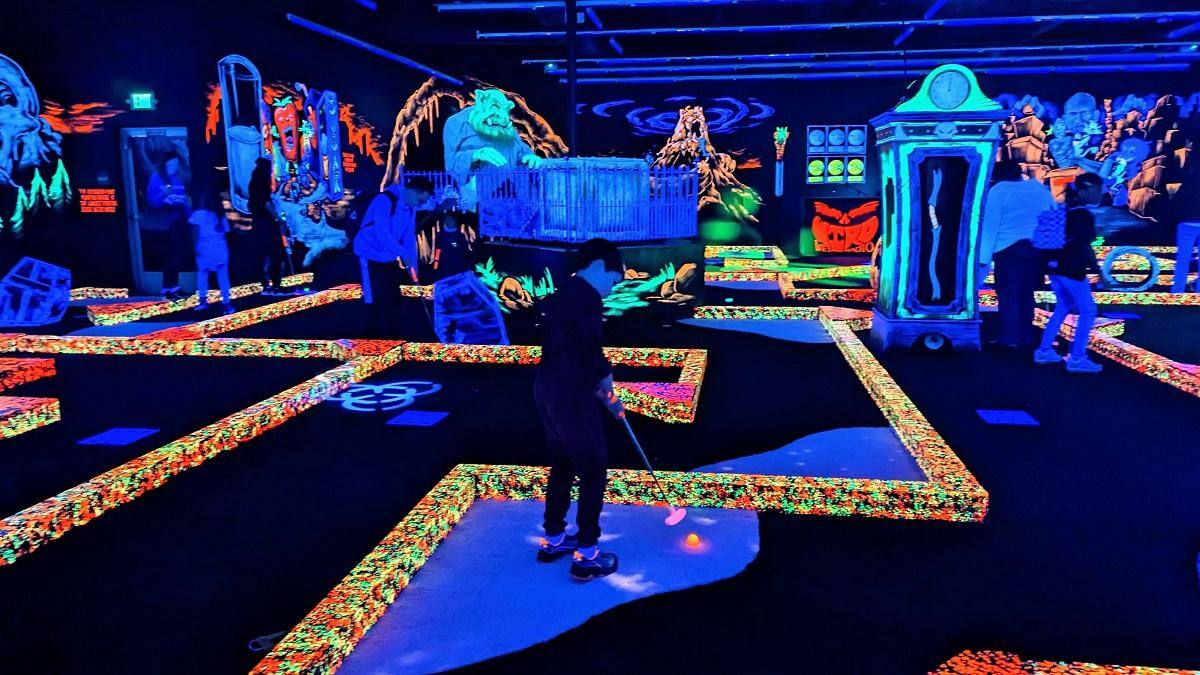 Monster Mini Golf blacklight mini golf boy putting credit Kate Missine_0